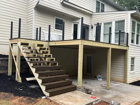 Deck stairs and framing over a new concrete patio