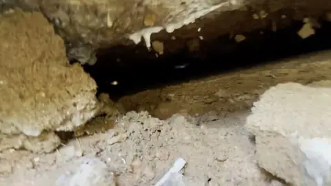 Close look at the ground under a damaged slab before repair