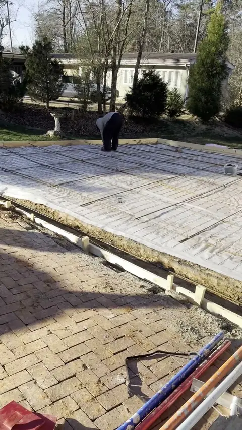 New slab meeting a brick paver patio