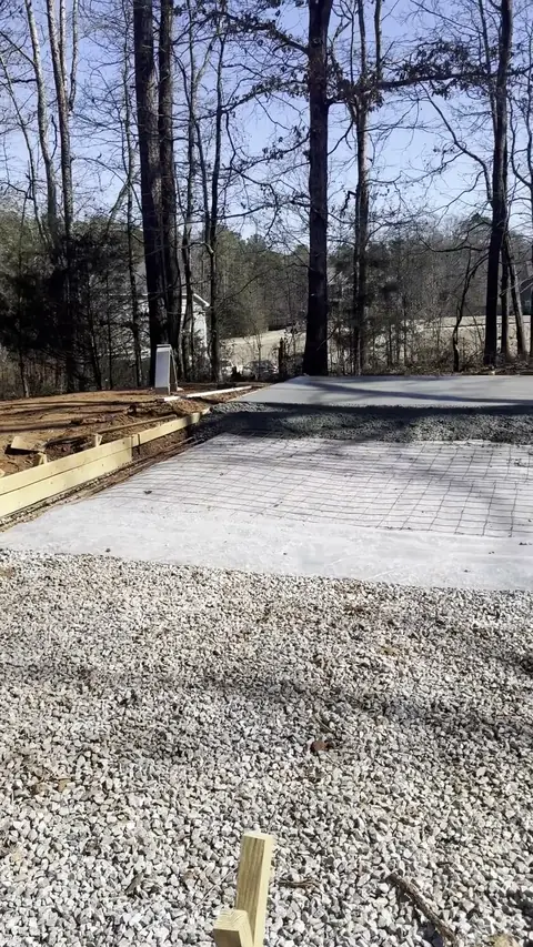 Concrete driveway with a fresh gravel base beside it