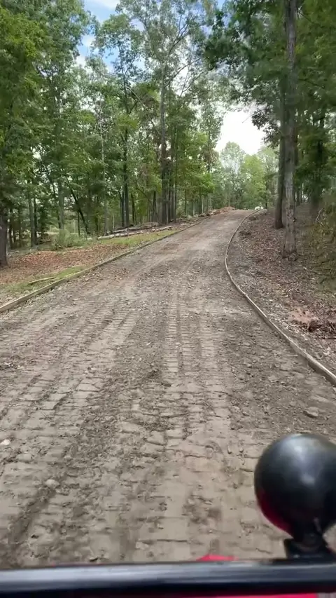 Gravel driveway graded through a wooded lot