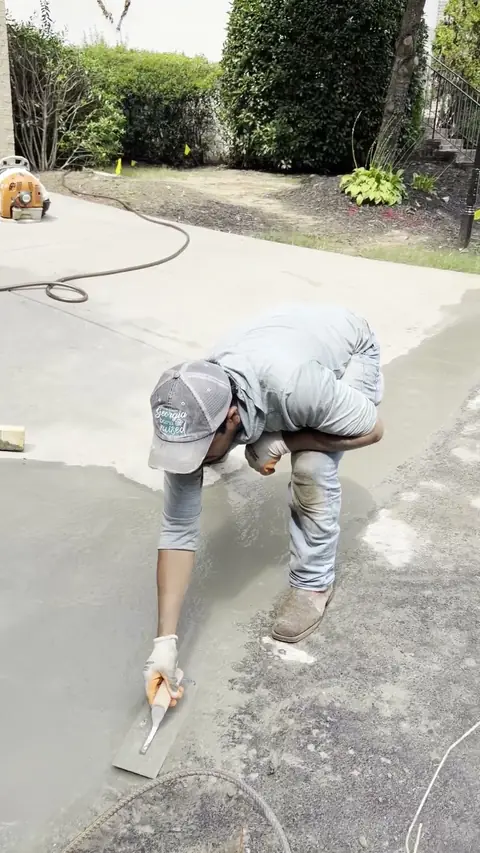 Driveway patch being finished by hand